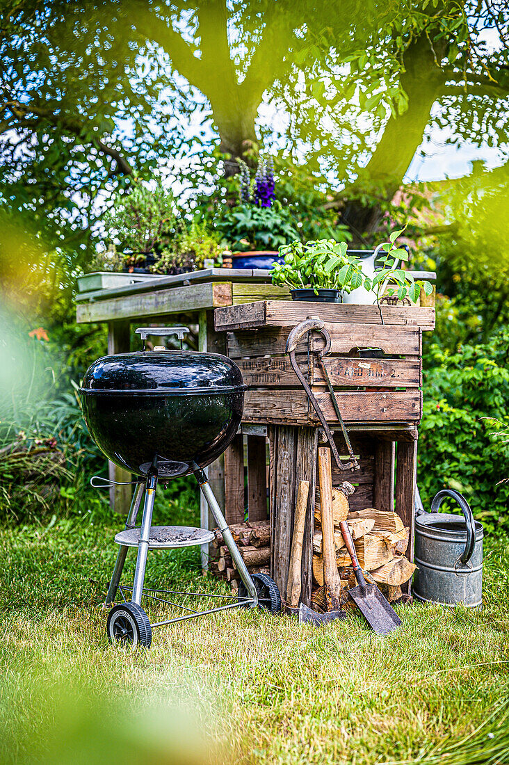 Ball grill in front of wooden boxes in the garden