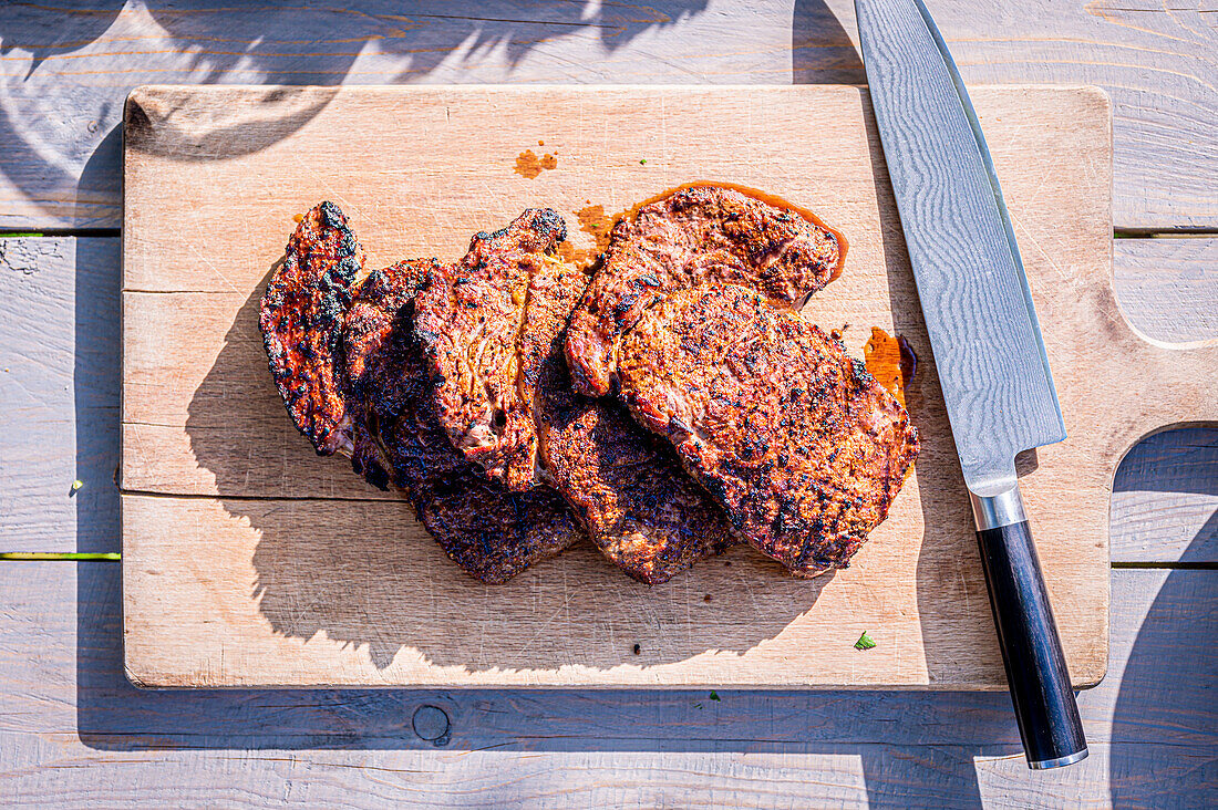 Grilled steaks on wooden board