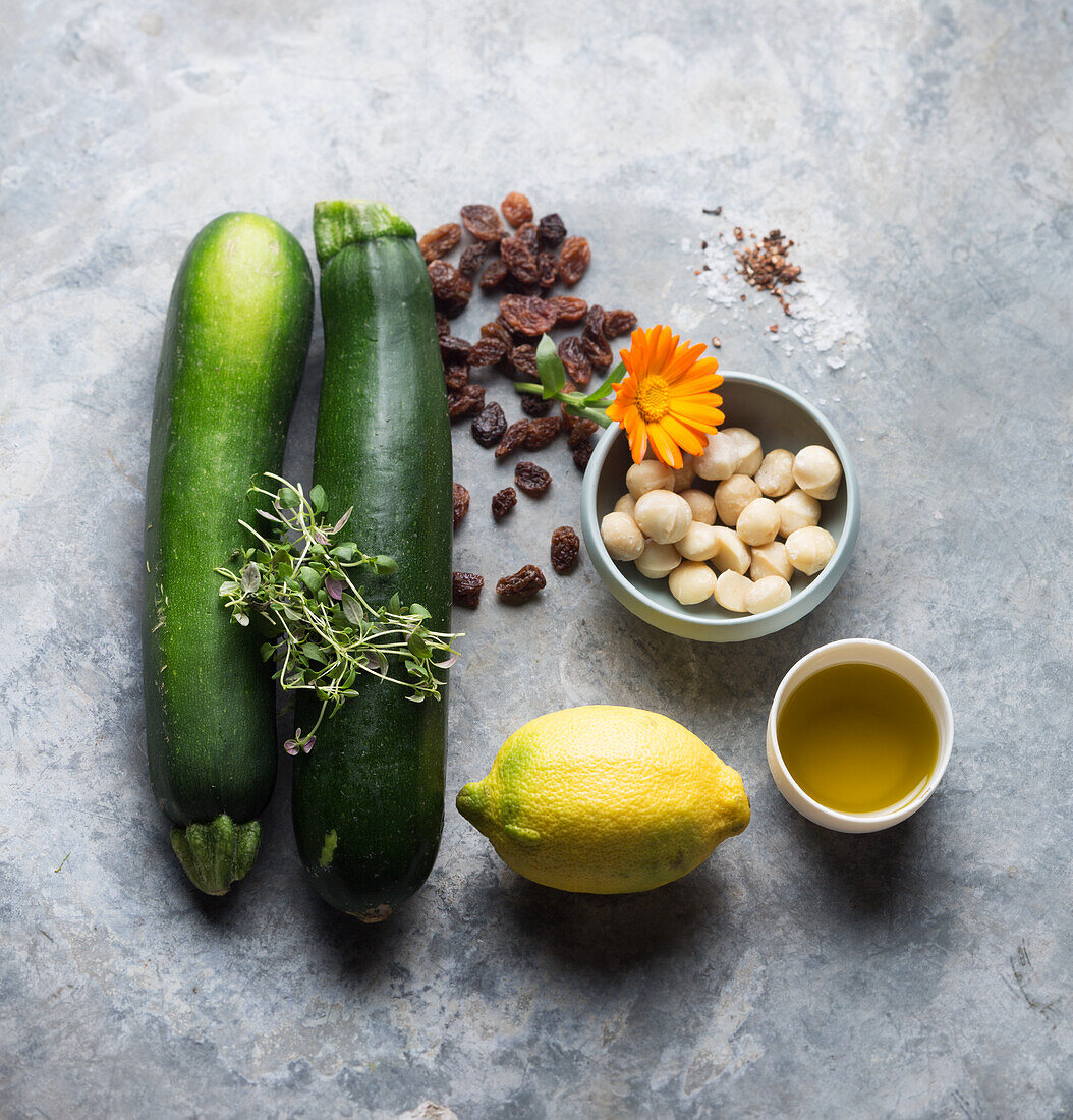 Ingredients for vegan zucchini noodles (zoodles) with macadamia and golden raisins