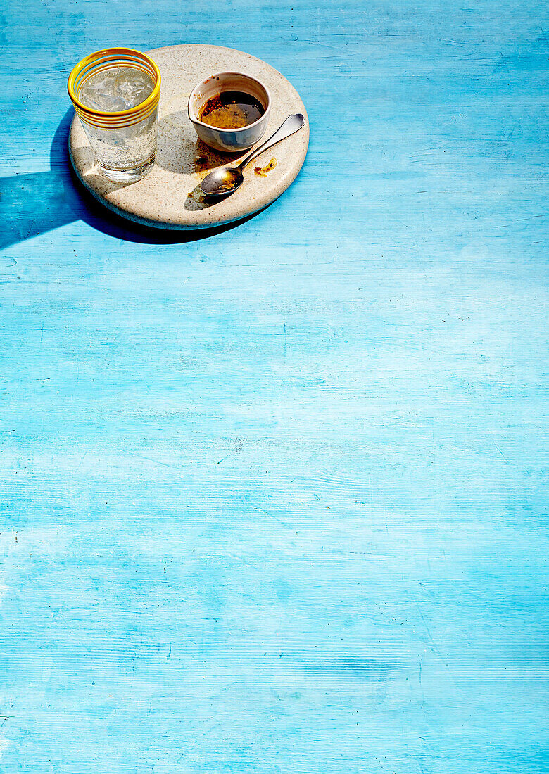 Kaffee und ein Glas Wasser auf blauem Untergrund