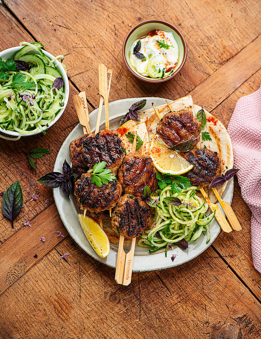 Meatballs on a skewer with cucumber salad