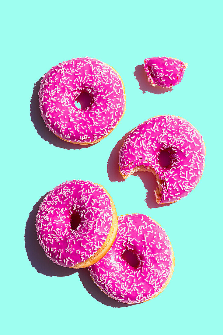 Donuts with pink icing on turquoise background