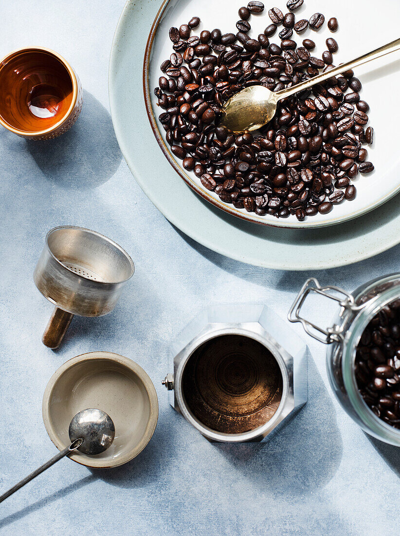 Stillleben mit Kaffeebohnen und Kaffeebereiter