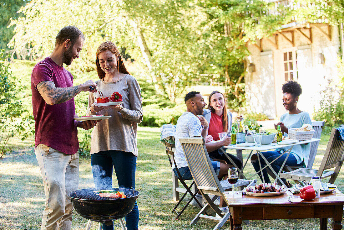 Junge Leute beim Grillen im Garten