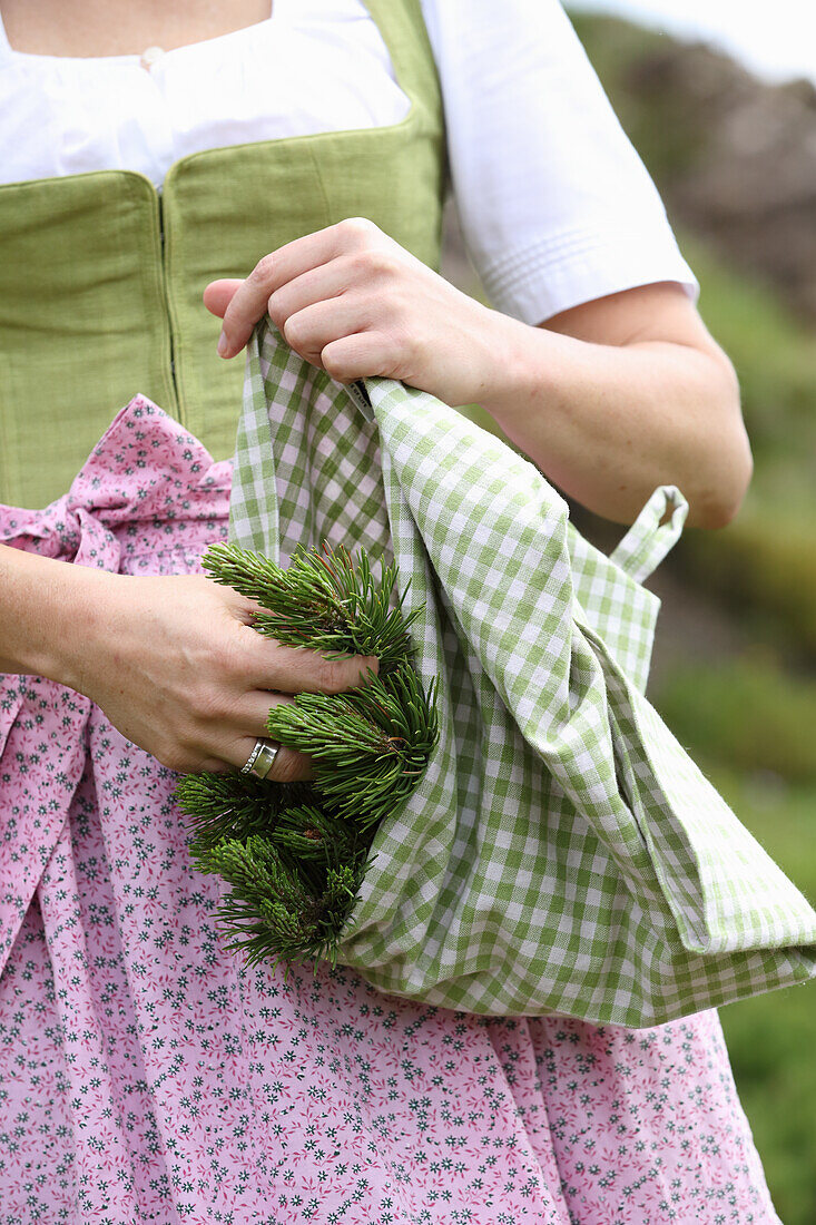 Woman collecting mountain pine needles