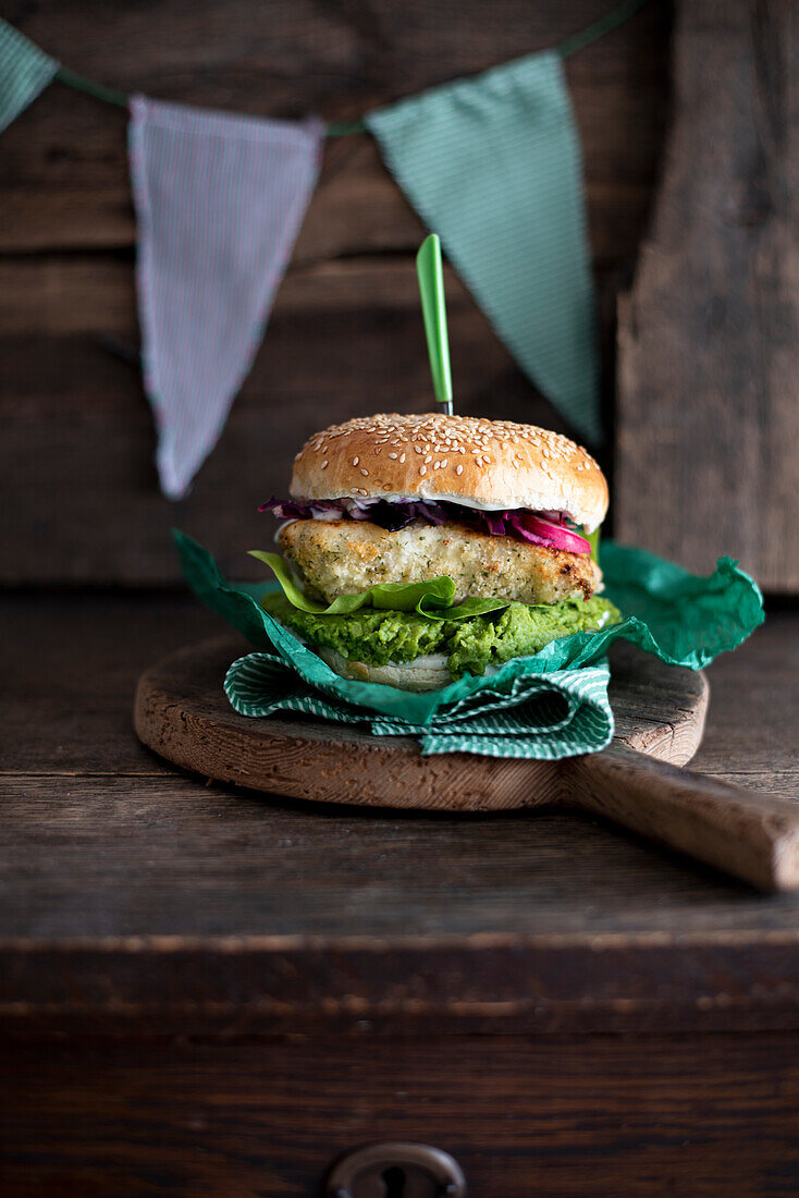 Fishburger with baked cod, mashed avocado, lettuce, pickled red onion and tartar sauce