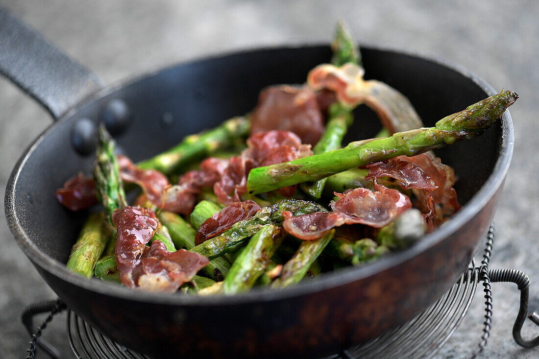 Green asparagus with bacon in a pan