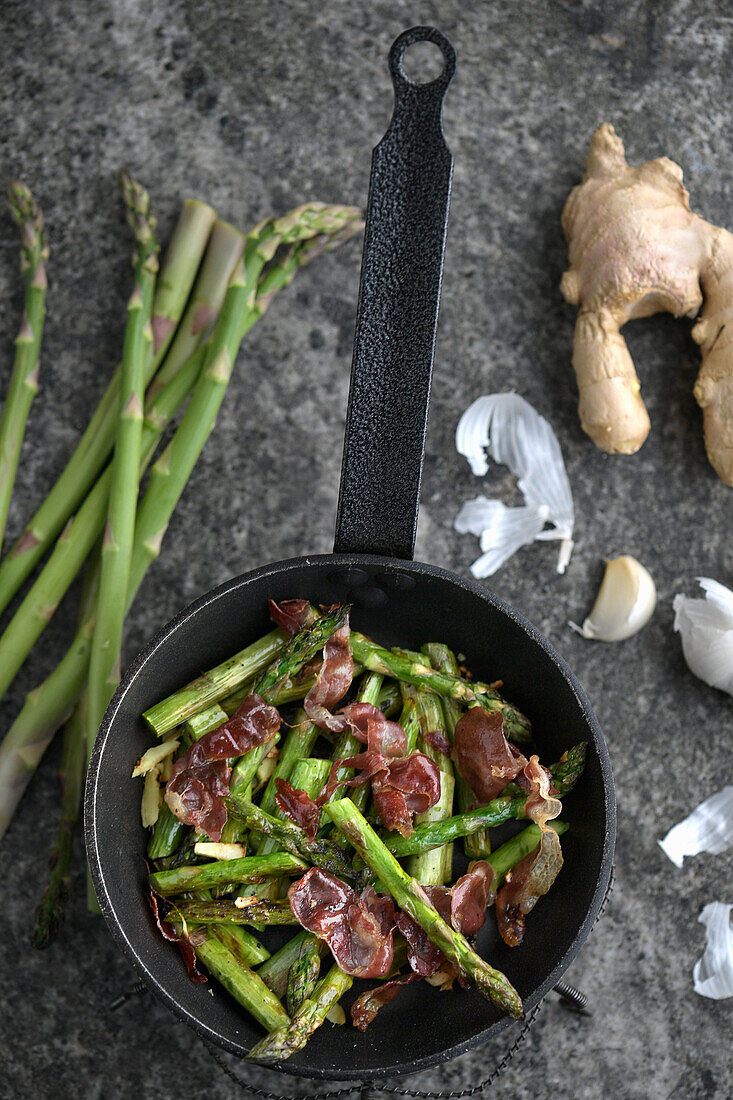 Grüner Spargel mit Speck in der Pfanne