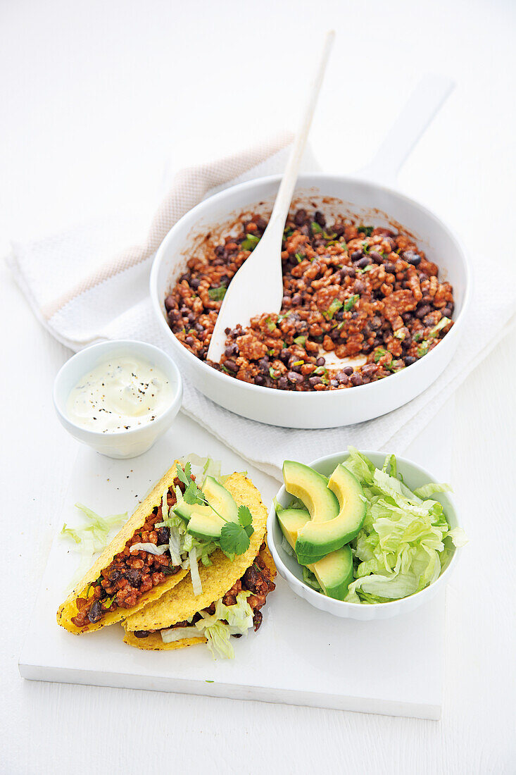 Tacos with ground pork, black beans, and avocado