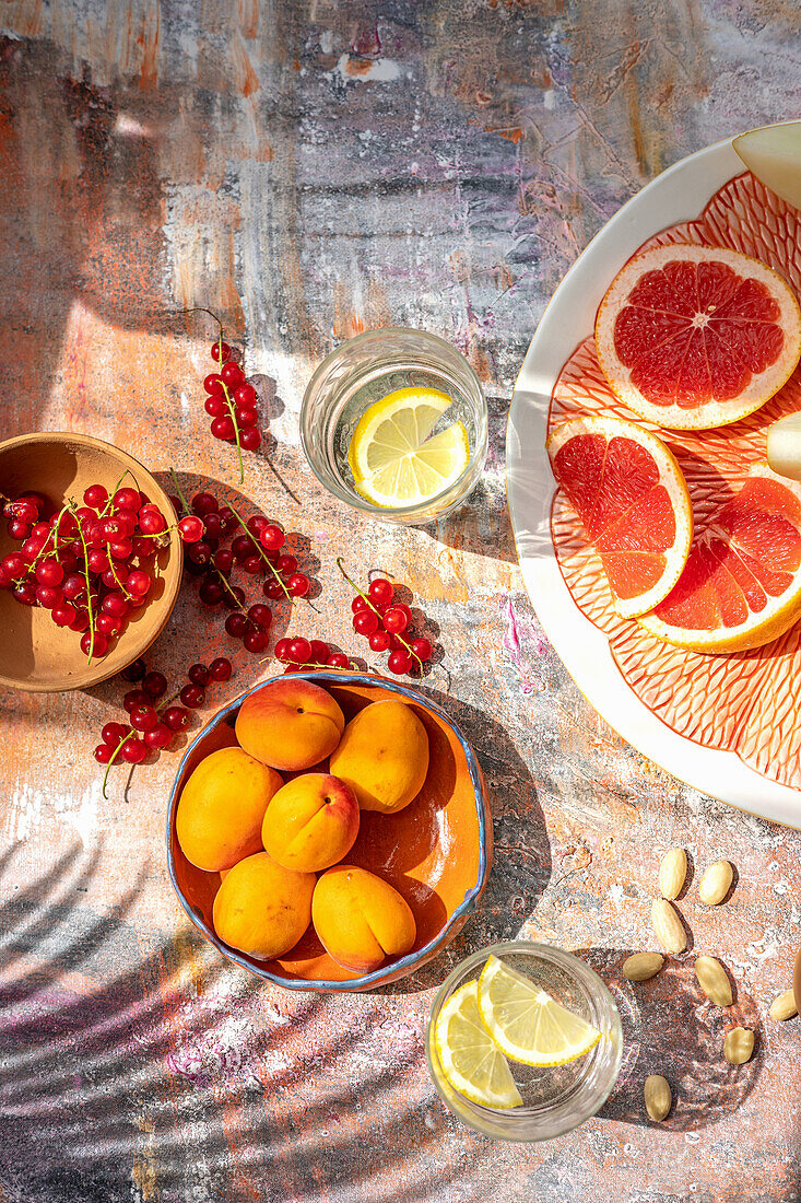Aprikosen, rote Johannisbeeren, Grapefruit, Mandeln, und aromatisiertes Wasser