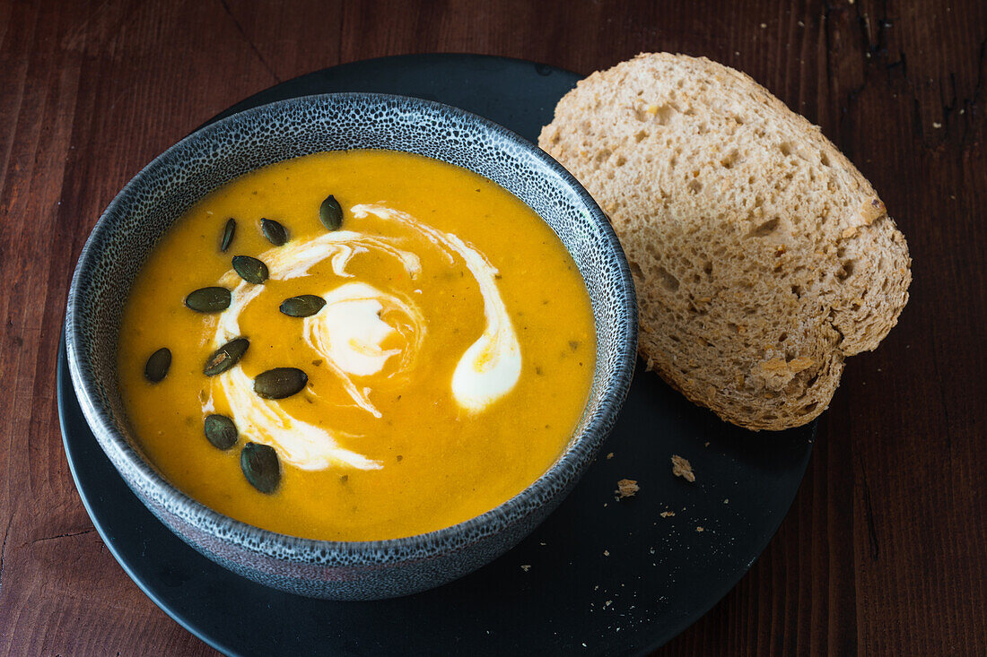 Kürbiscremesuppe mit Kürbiskernen und Brot