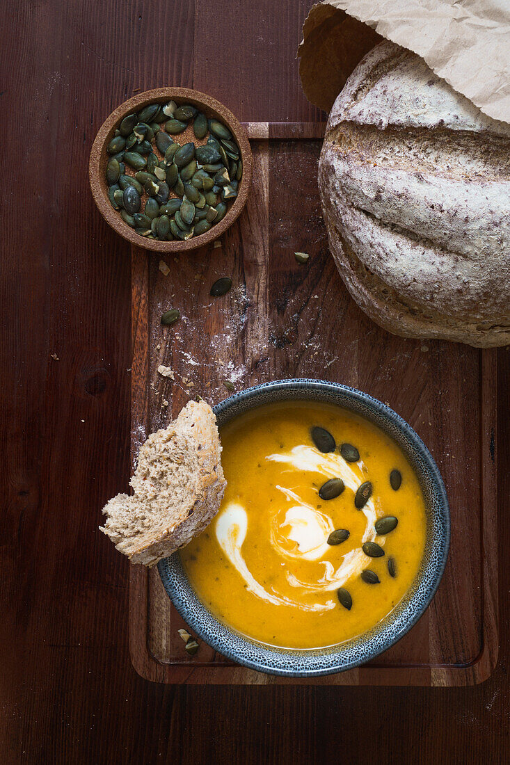 Kürbiscremesuppe mit Kürbiskernen und Brot