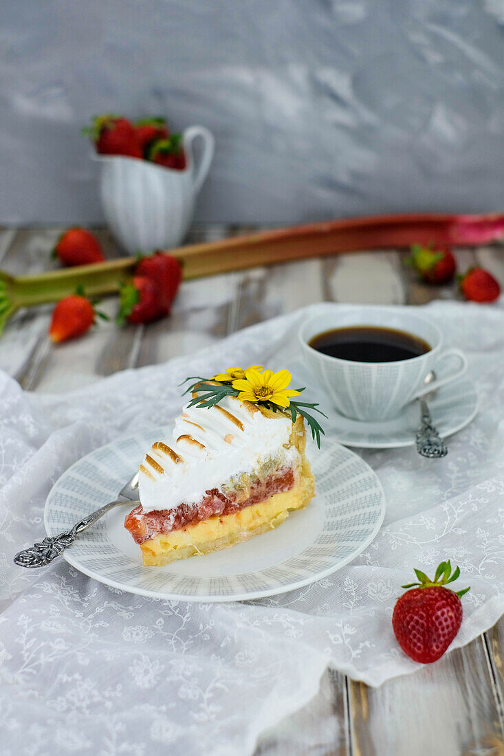 A slice of rhubarb meringue pie with a cup of coffee