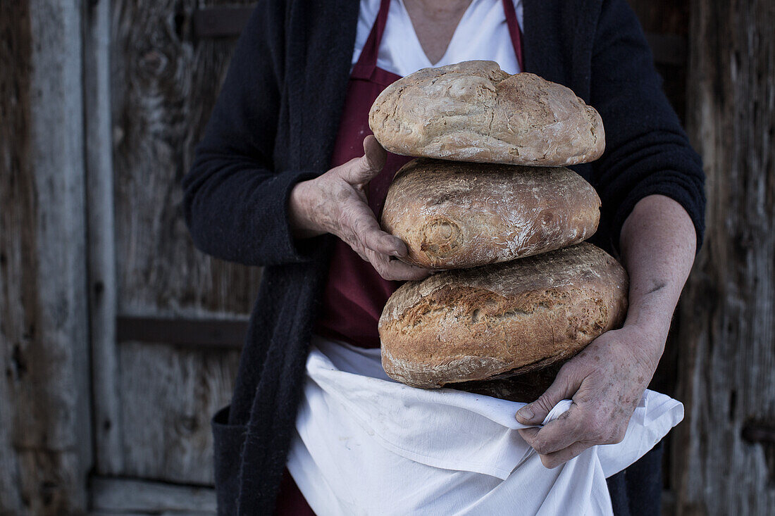 Baker with freshly baked bread loaves