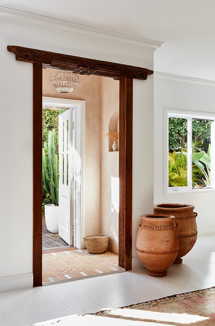 Terracotta vessels on wooden Indian door frame