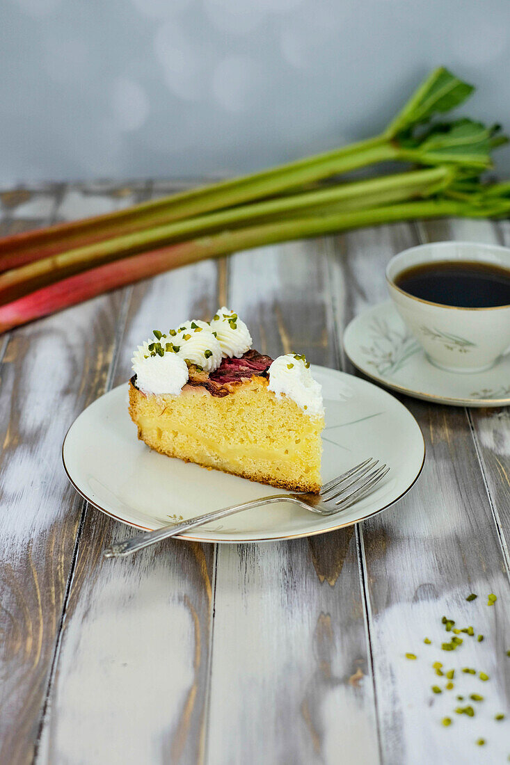 A piece of rhubarb custard tart on a plate with coffee