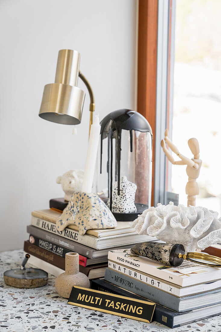 Books and art materials on a desk with terrazzo top