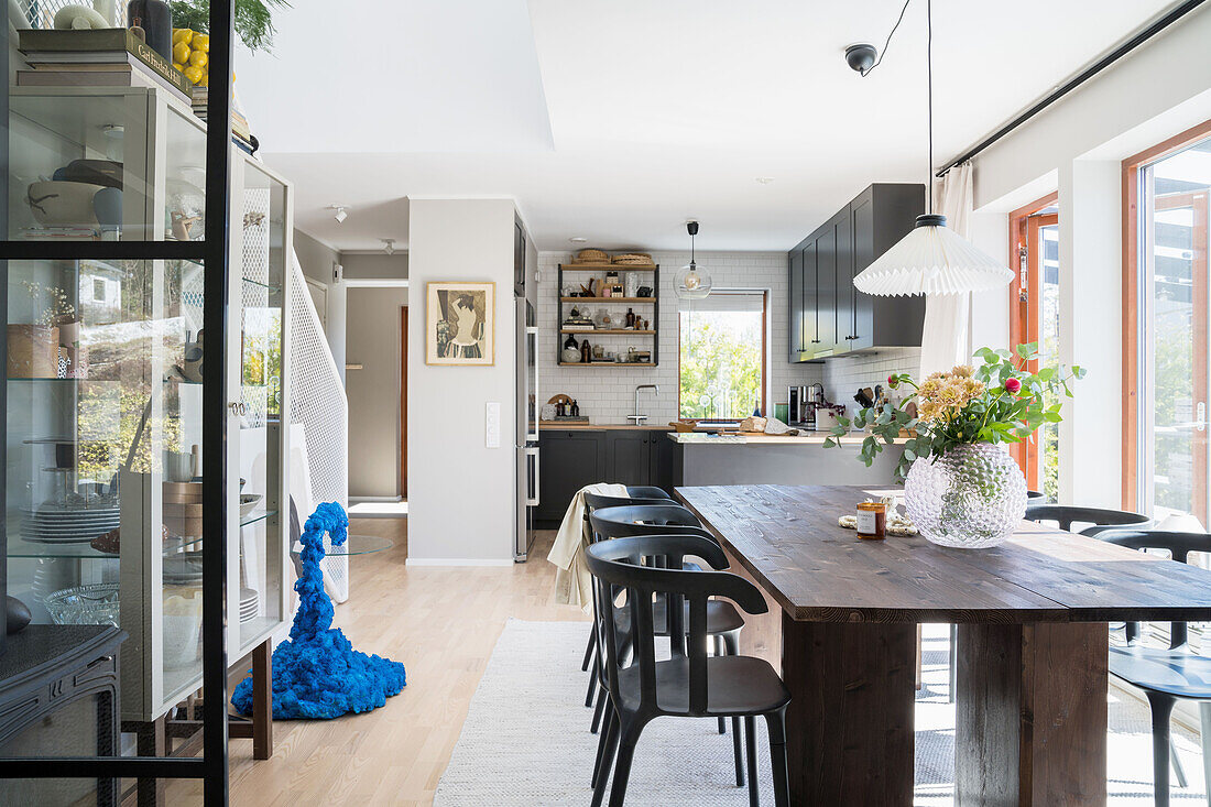 Dining area with wooden table and glass cabinet in an open plan living room