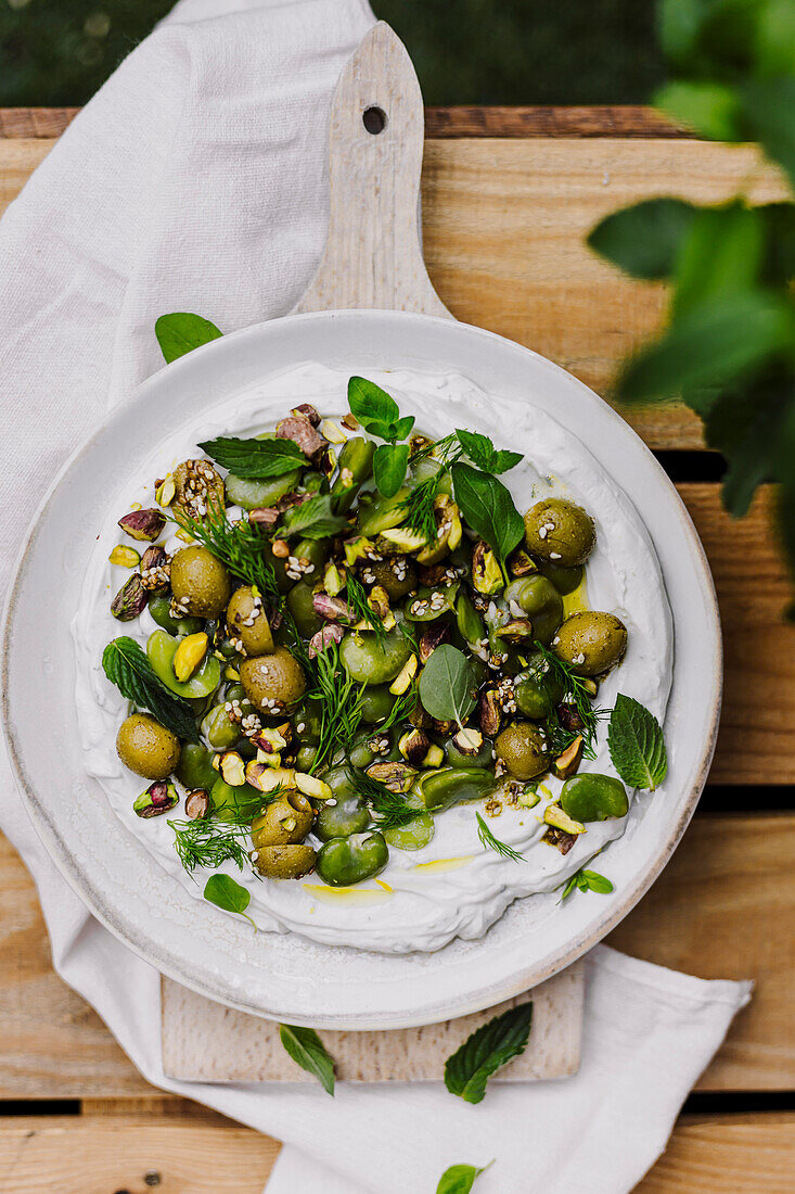 Broad beans with olives and herbs on labneh