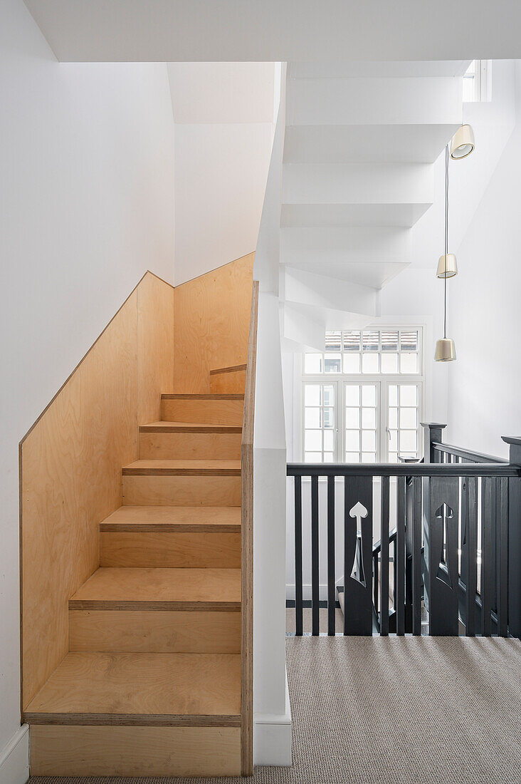 White staircase with wooden steps and black railing