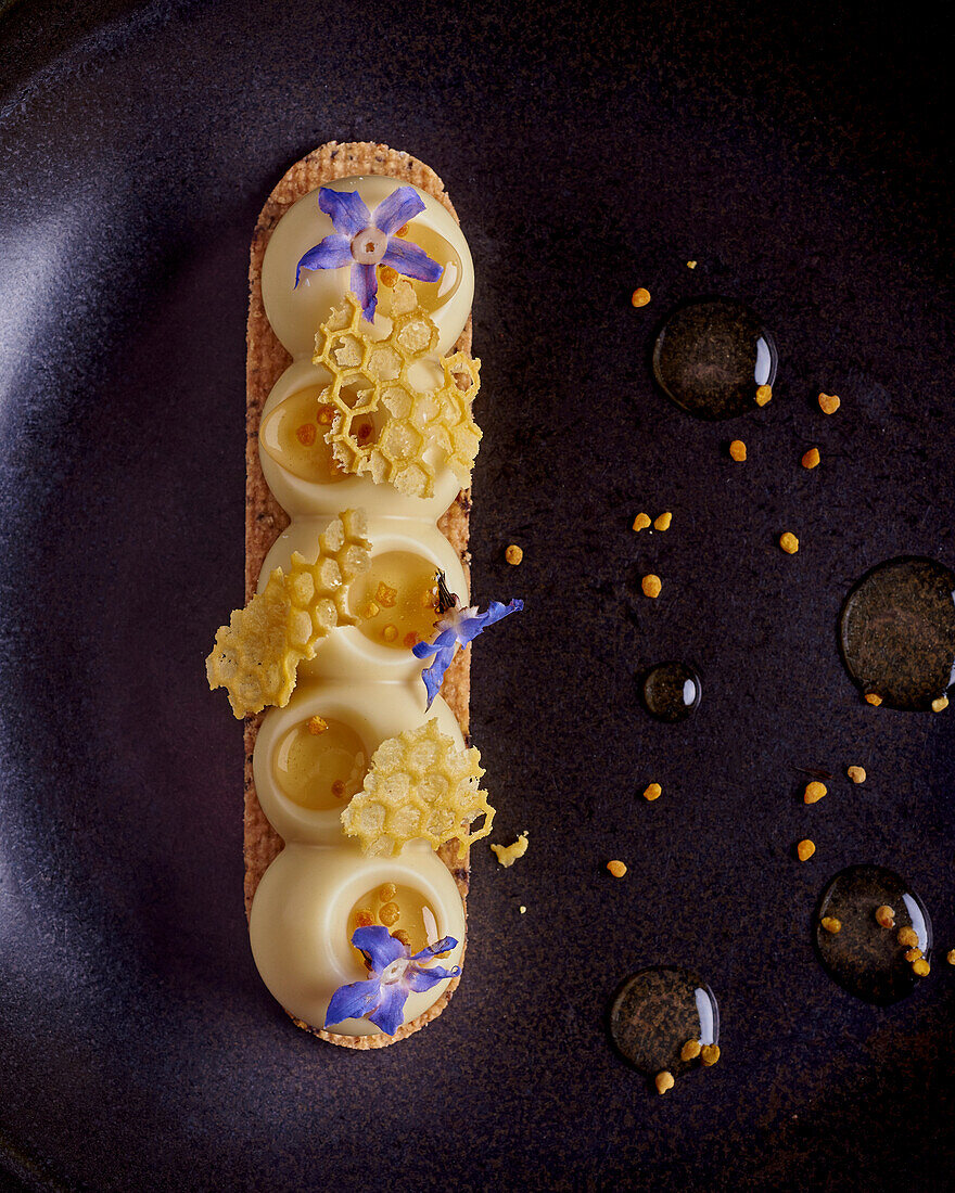Honey dessert with white chocolate and blue blossoms (close-up)