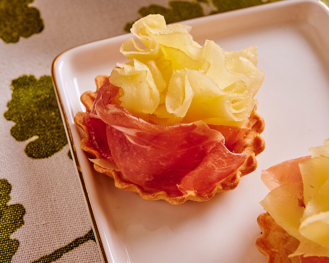 Puff pastry tartlets with ham and tete de moine