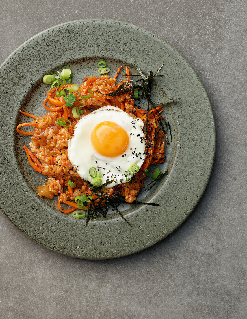 Kimchi Fried Rice with fried egg, carrots and spring onions (Asia)