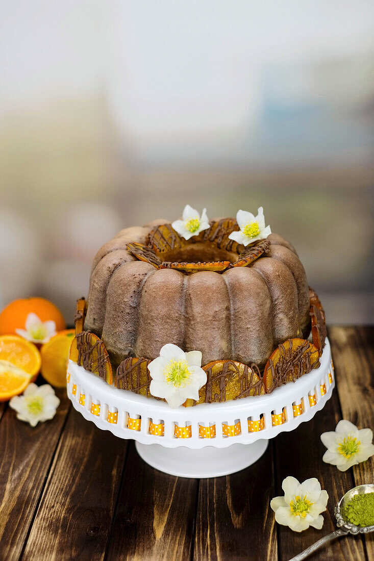 Orange and matcha gugelhupf decorated with Christmas blossoms