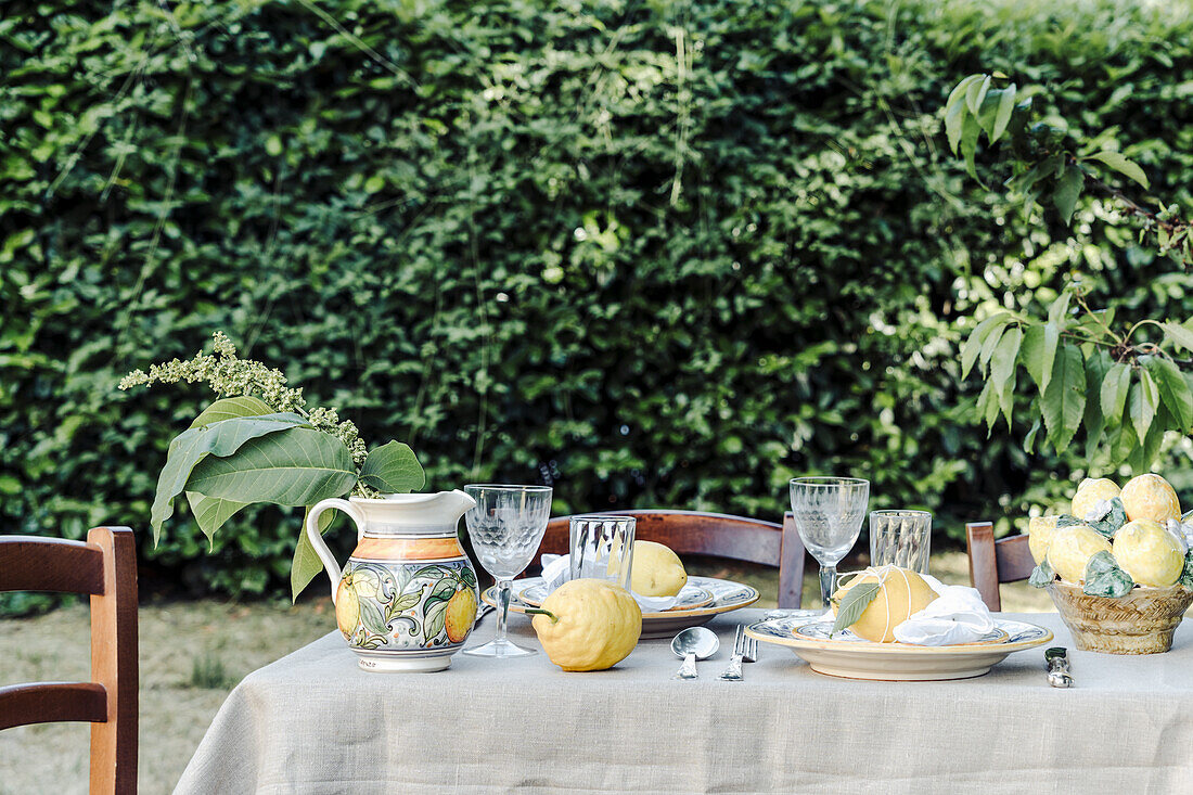 Set table decorated with lemons, in the garden