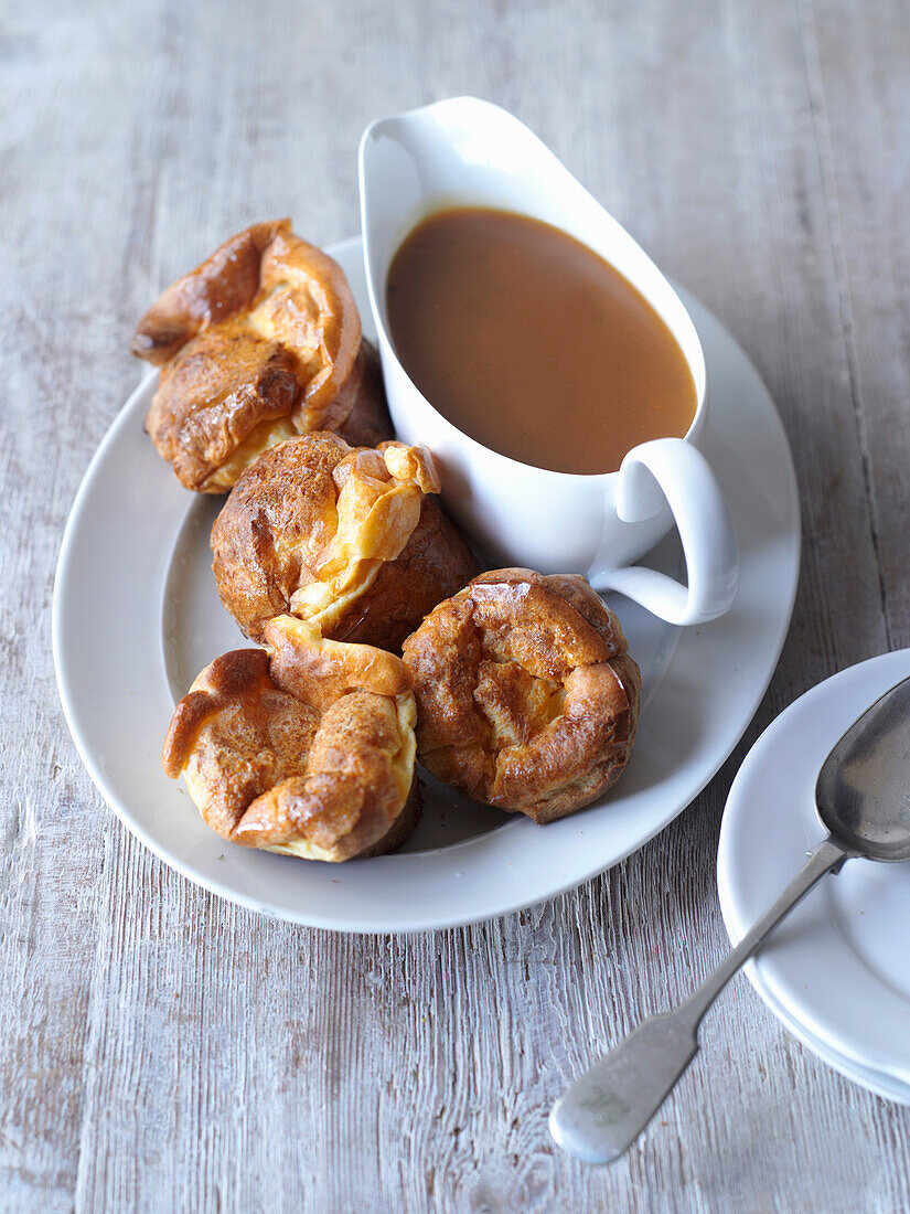 Yorkies with sauce in gravy boat (Yorkshire puddings)