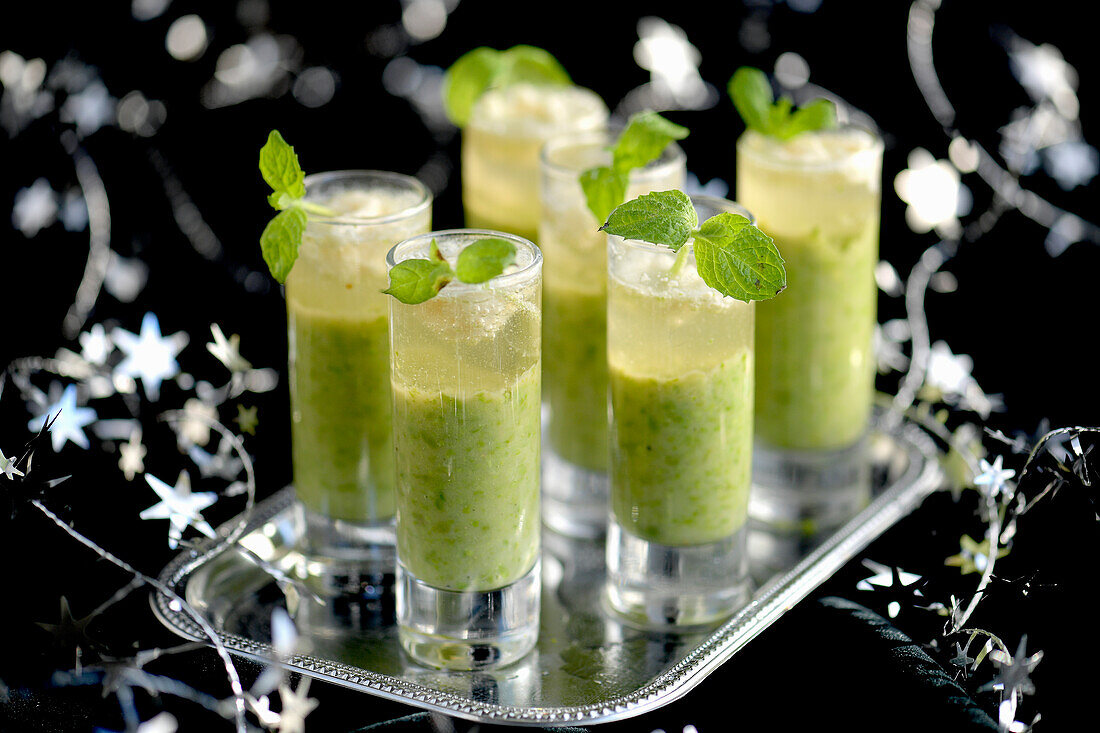Festliche grüne Erbsensuppe serviert in Gläsern