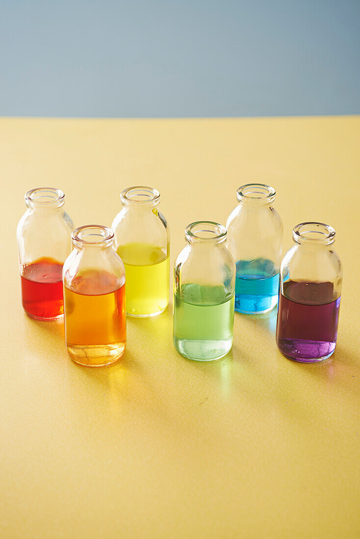 Regenbogenfarben Wasserfarben in Gläsern