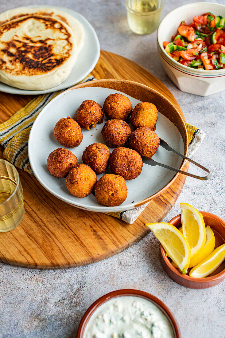 Butternusskürbis-Falafel, serviert mit cremigem Feta, Fladenbrot und Salat