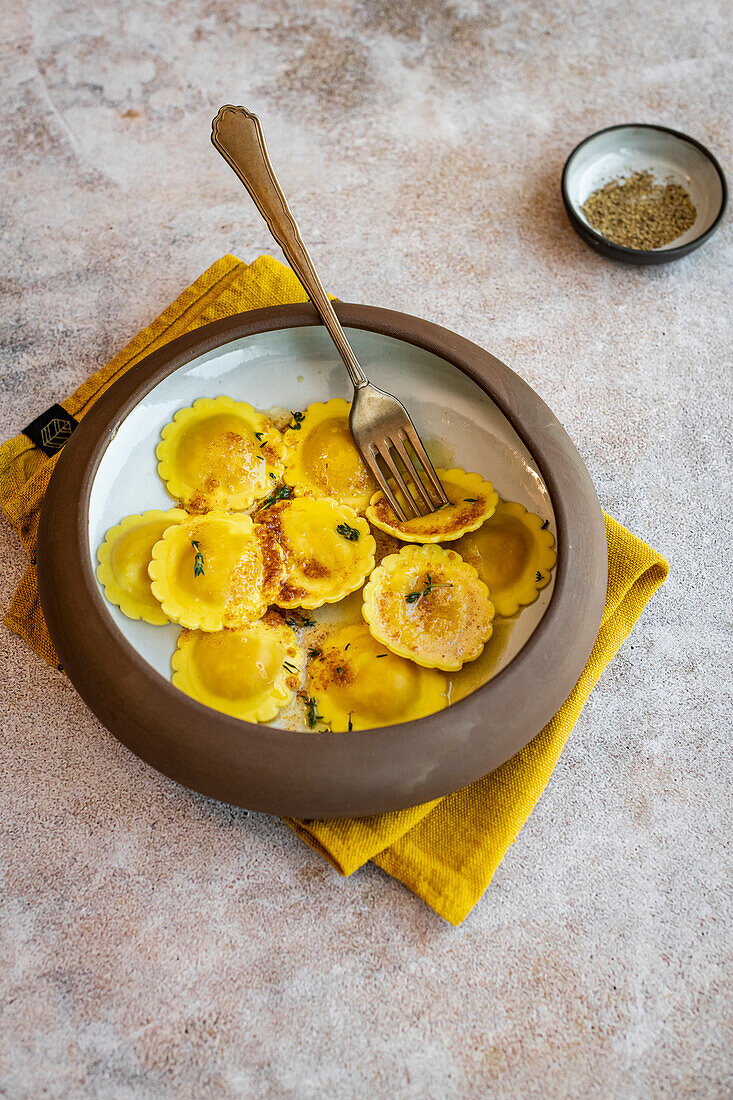 Butternusskürbis-Ravioli serviert mit gebräunter Butter, Miso und Thymian