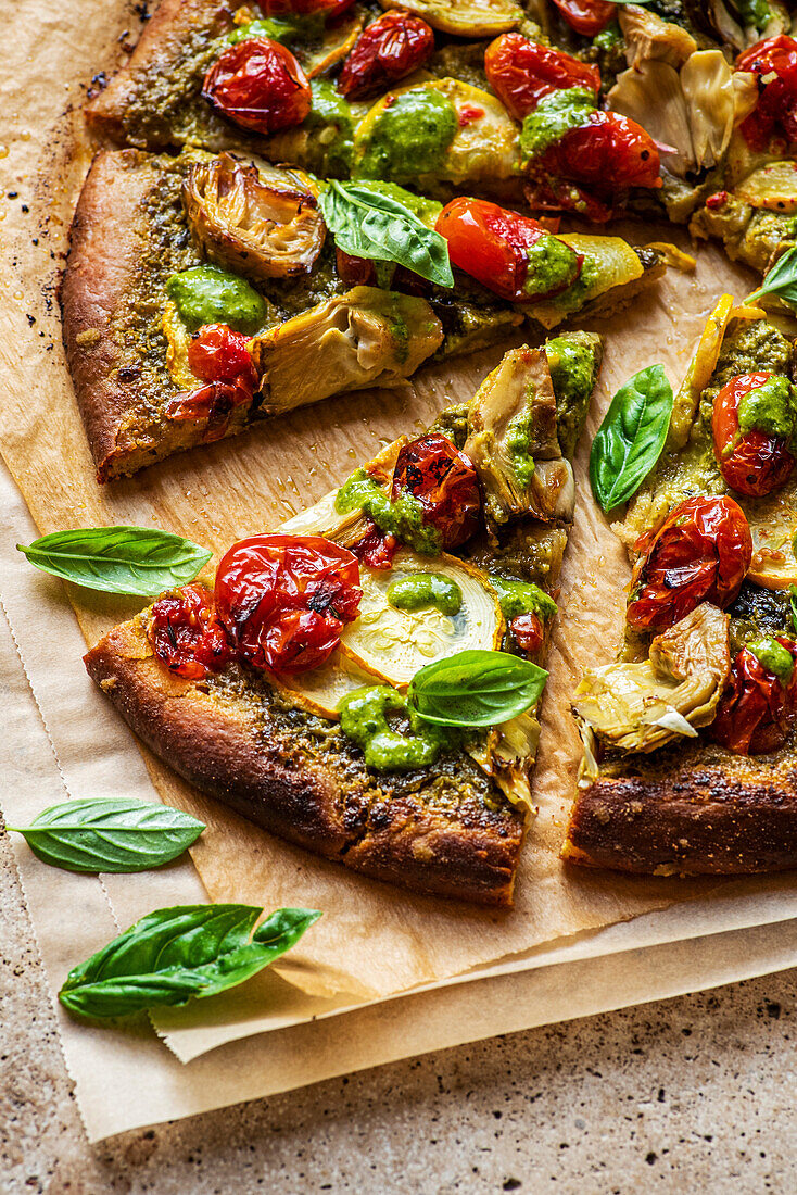 Vegan Pesto Pizza, sliced on a wooden cutting board