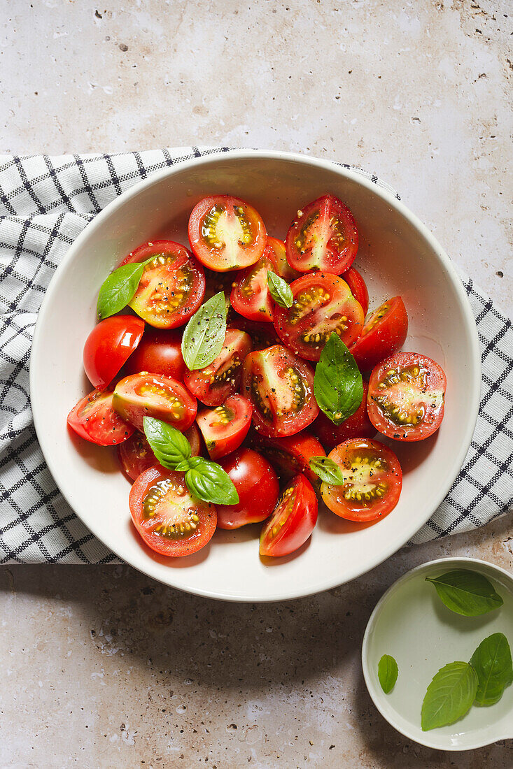 cherry tomatoes with basil leaves in a bowl