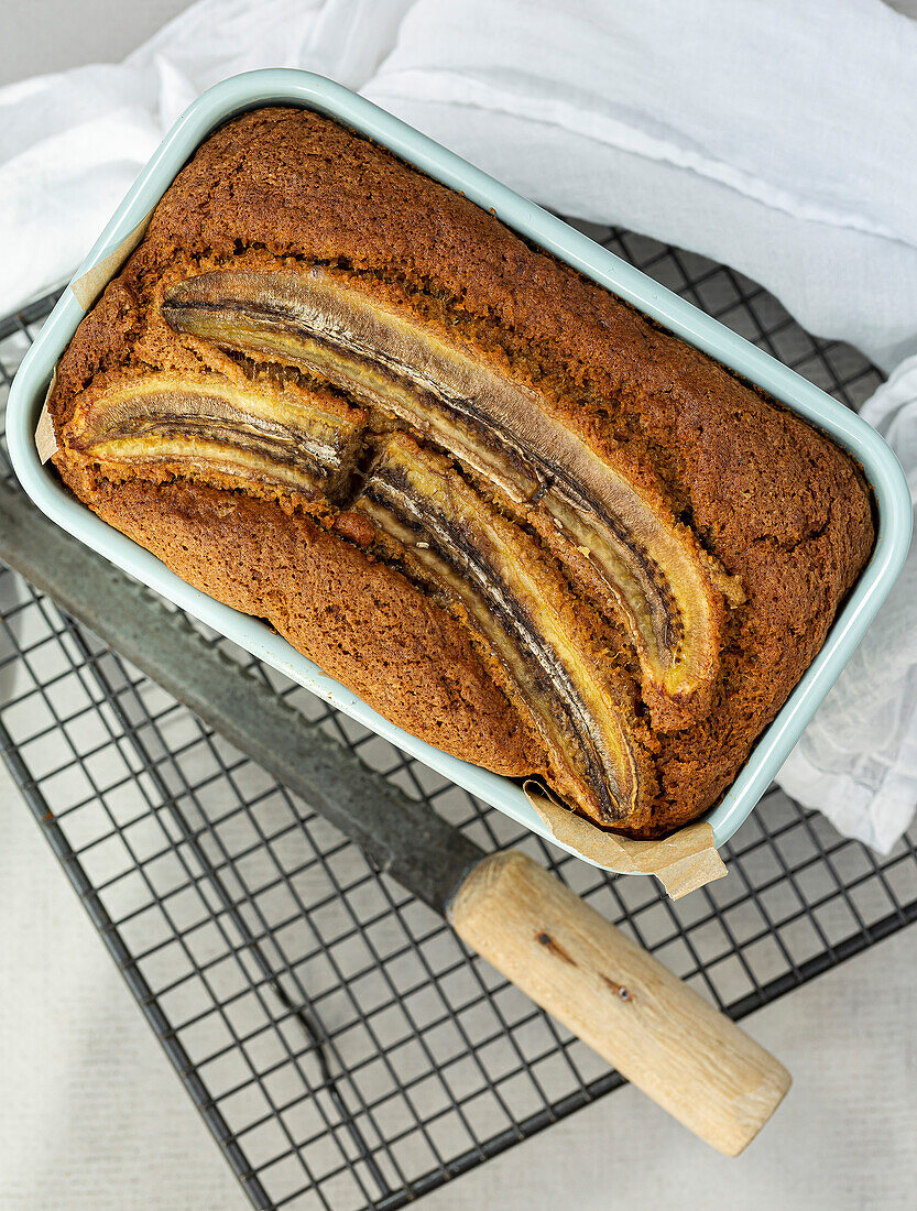 Banana Bread loaf cake in a tin, on a cooling rack