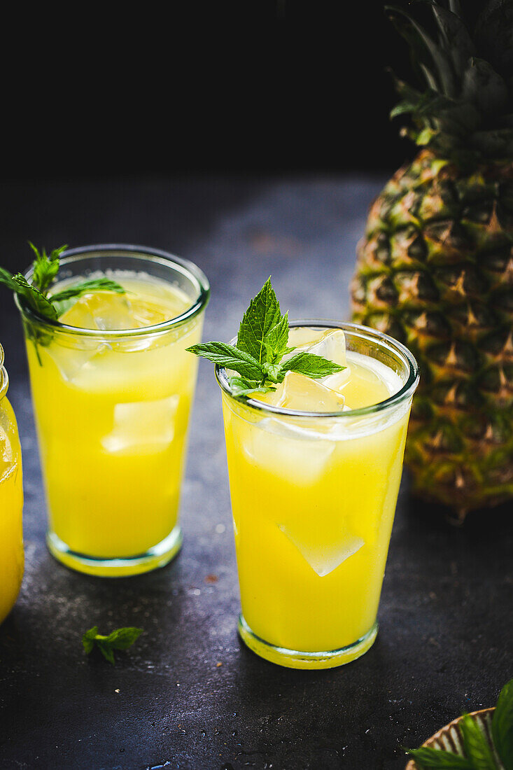 Frischer Ananassaft mit Eiswürfeln und Minze