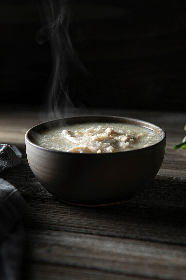 Steamy bowl of Chicken Jook in a rustic kitchen
