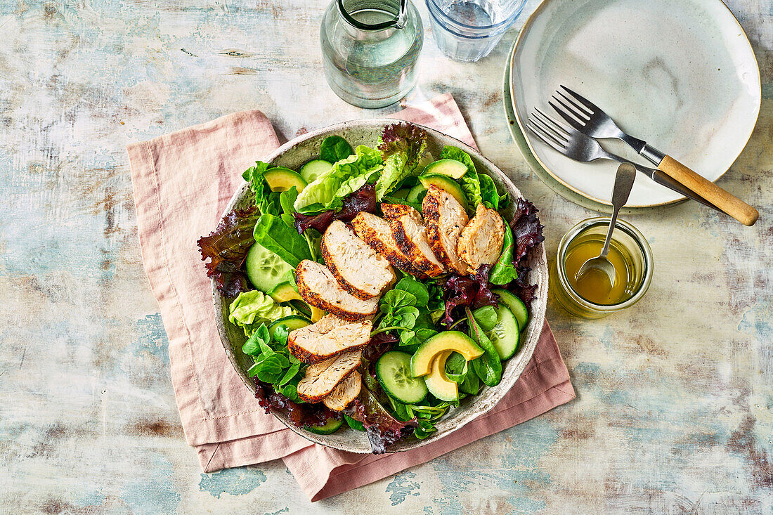 Leaf salad with chicken breast, avocado, and cucumber