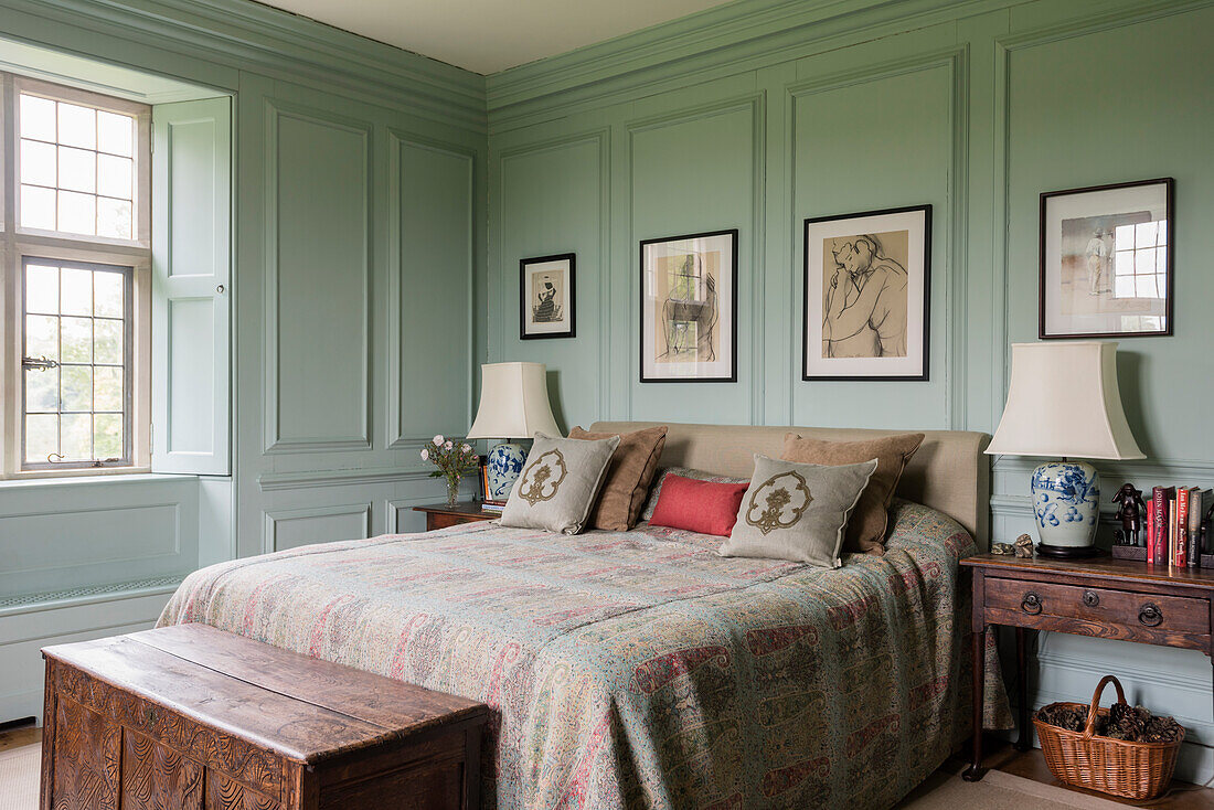 Queen bed with wool and silk bedspread in a bedroom with coffered walls