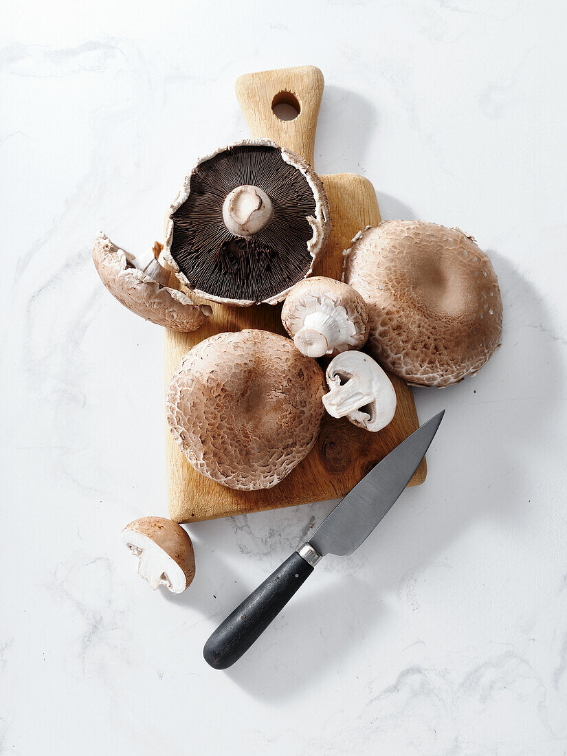 Portobello mushrooms on a wooden chopping board