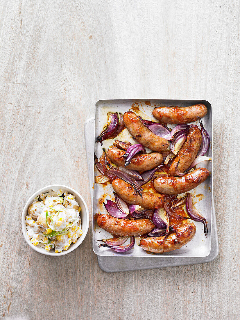 Sticky sausages with potato and corn salad