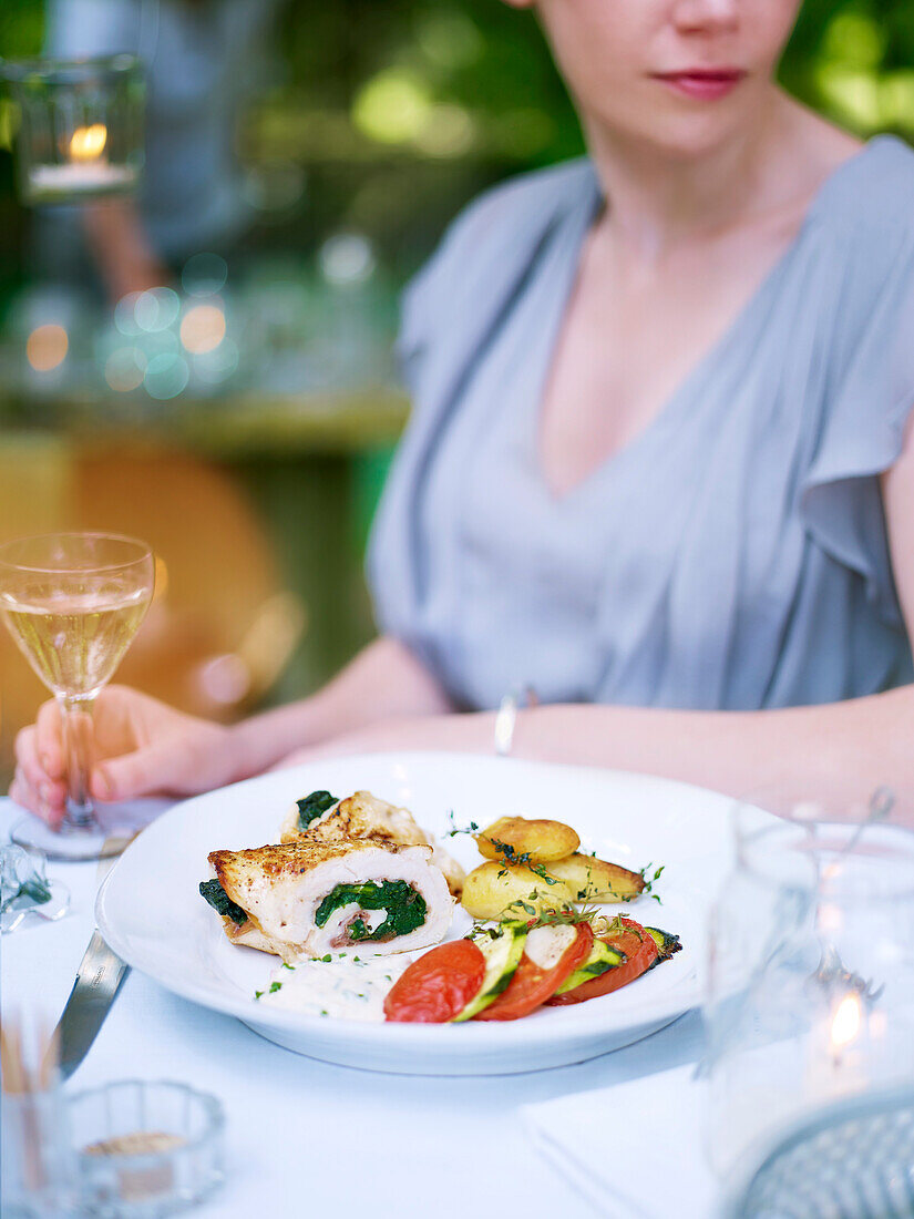 Chicken breast stuffed with ham and spinach served with zucchini tomato tian