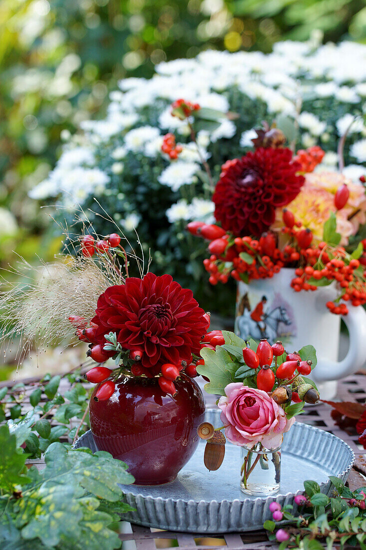 Autumn table with dahlia, rose, rosehips, and acorns