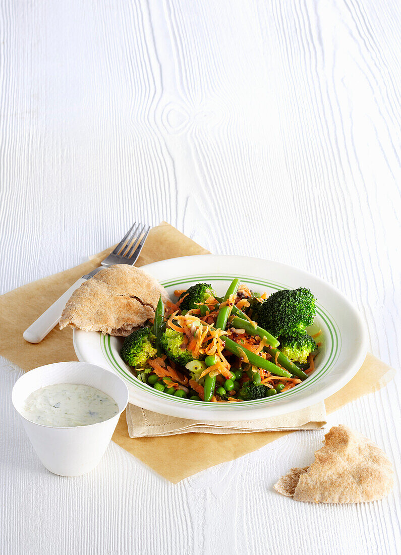 Beans, broccoli, and peas with dip and pita bread