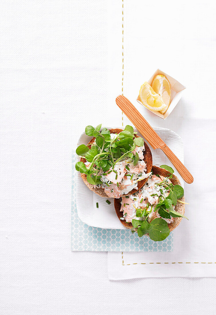 Bagel with chive salmon topping with salmon and watercress