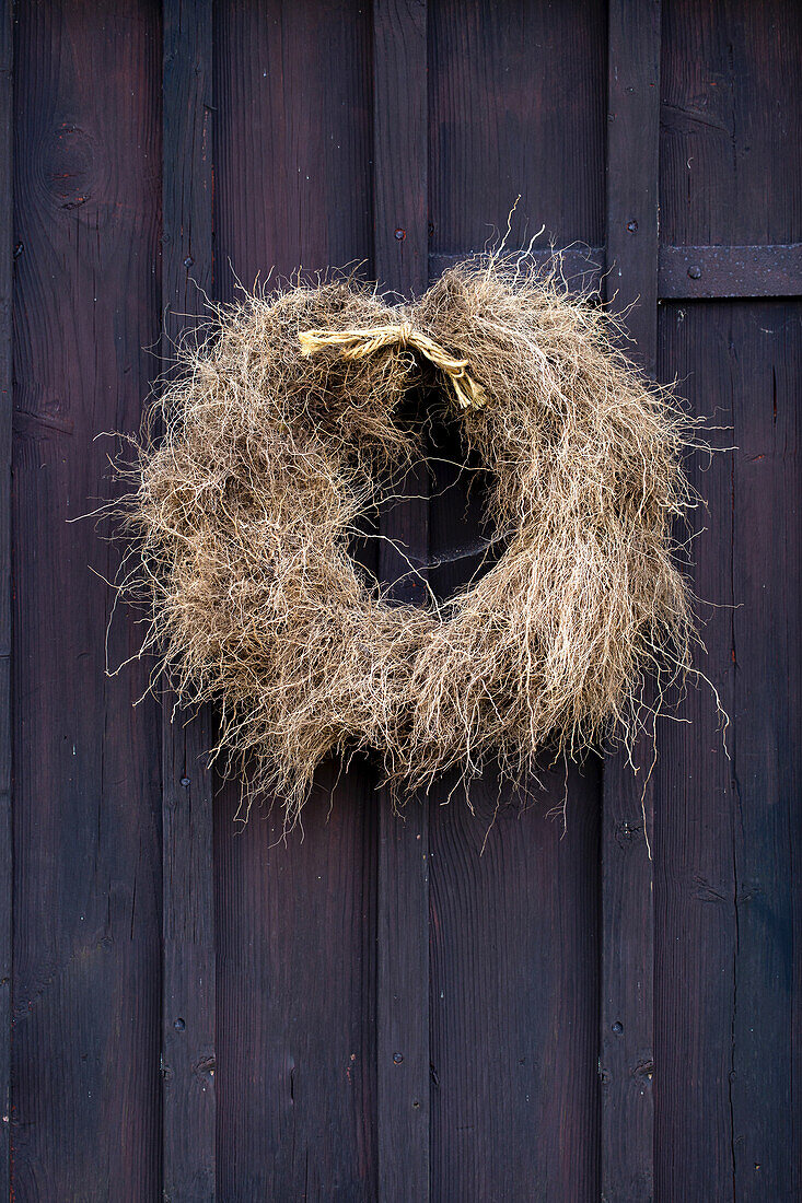 Wreath of dried zinnia roots on a wooden door