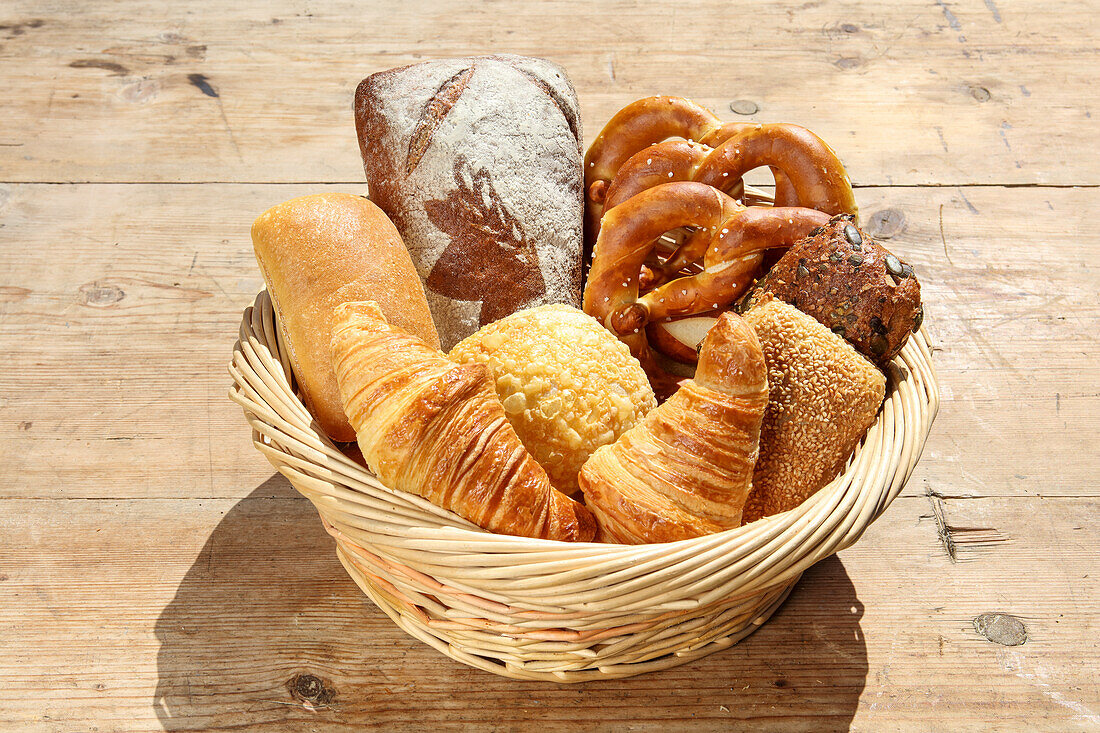 Assorted fresh baked goods in basket on wooden table