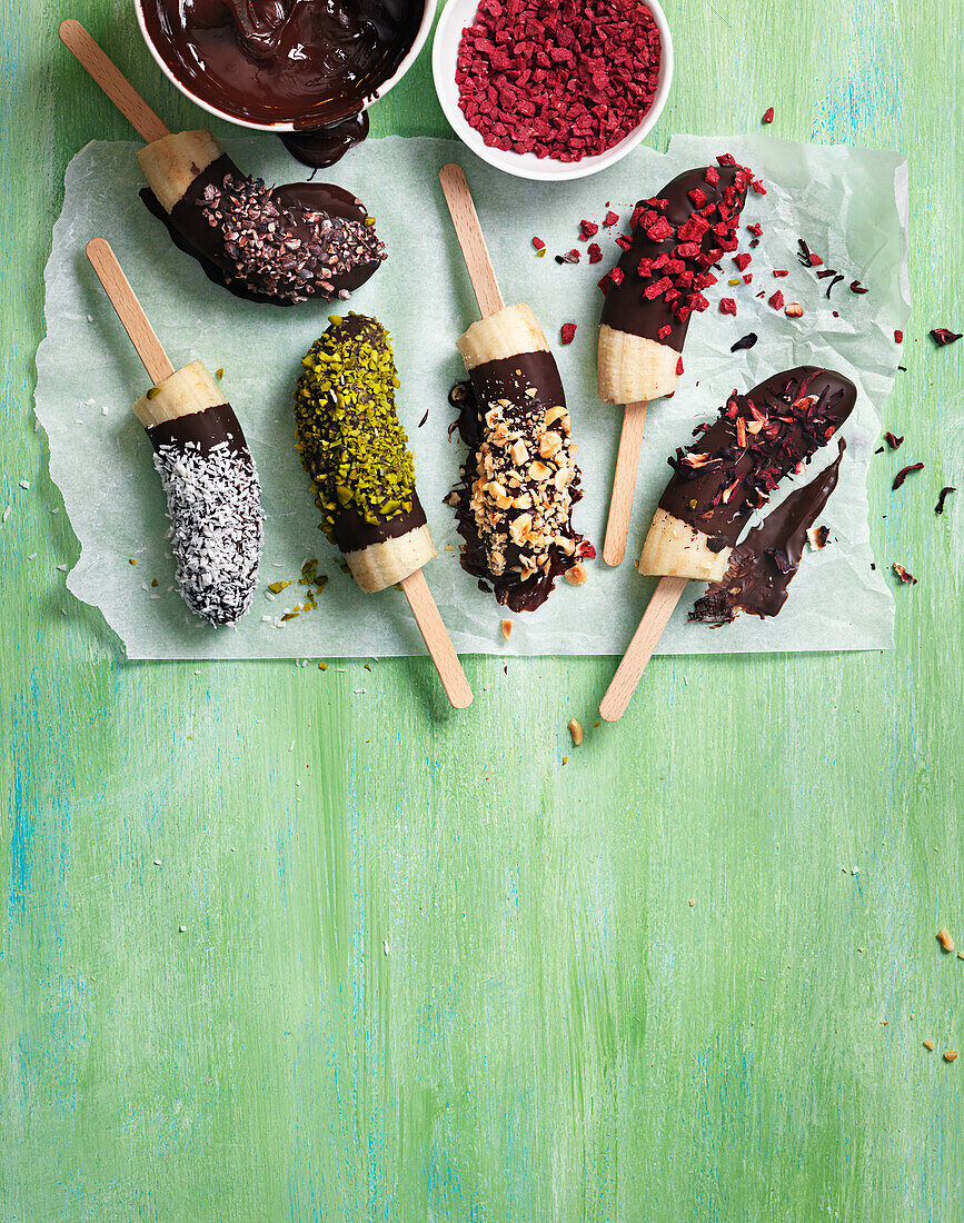 Banana pops with various toppings - chocolate, nuts, coconut, cocoa nibs